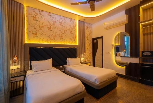 a hotel room with two beds and a mirror at Aman Homestay, A Boutique Hotel in Agra
