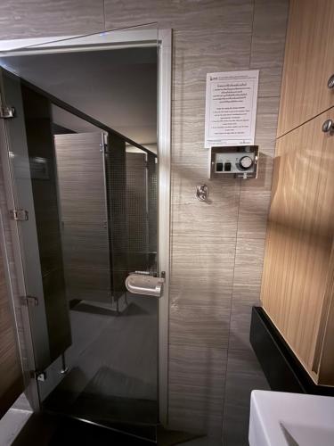 a bathroom with a shower with a mirror and a sink at Del Mare Bangsaley condo in Bang Sare