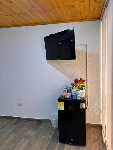 a room with a black refrigerator and a tv on the wall at Apartamentos Paipa Boyacá "Las Quintas" Pisos 2 y 3 in Paipa