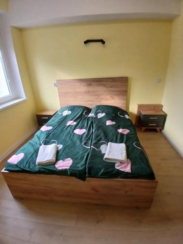 a bedroom with a bed with a green comforter at Marshal Foch Apartment in Grudziądz