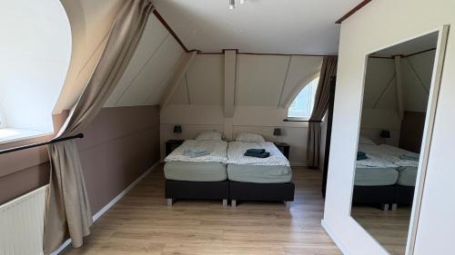 two beds in a small room with an attic at Holiday Beach House Hellevoetsluis in Hellevoetsluis