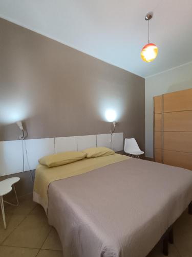 a bedroom with a large white bed and two chairs at Casa Letizia in Lercara Friddi