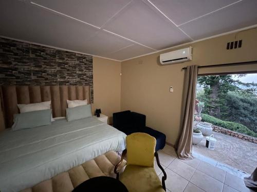 a bedroom with a bed and a large window at Mafofolozi Lodge in Hartbeespoort
