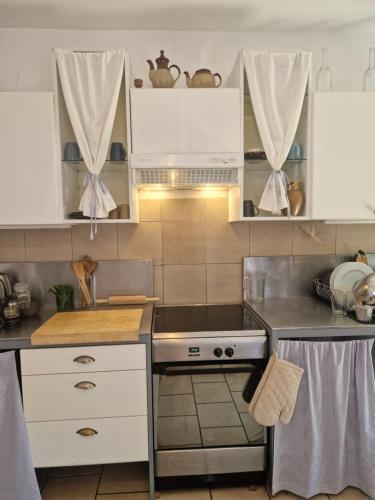 a kitchen with white cabinets and a stove top oven at COTTAGE - Utopy Hostel in Capbreton