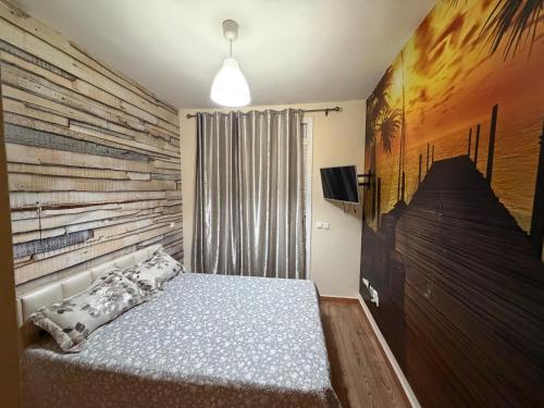 a bedroom with a bed and a wooden wall at Appartement calme avec piscine et proche de la plage in Fnidek
