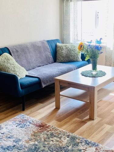 a living room with a blue couch and a coffee table at Kauba 6-6 Apartment in Kuressaare
