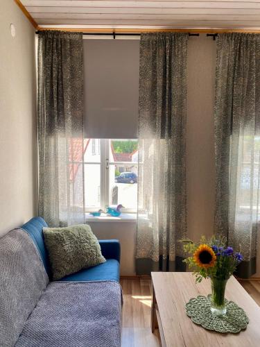 a living room with a blue couch and a table at Kauba 6-6 Apartment in Kuressaare
