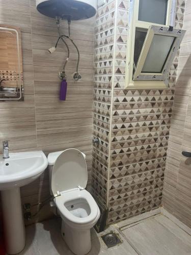 a bathroom with a toilet and a sink and a mirror at White Bay Ras Sedr وايت باي راس سدر in Ras Sedr