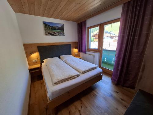 a small bedroom with a bed and a window at Appartment Sonnenkogel in Holzgau