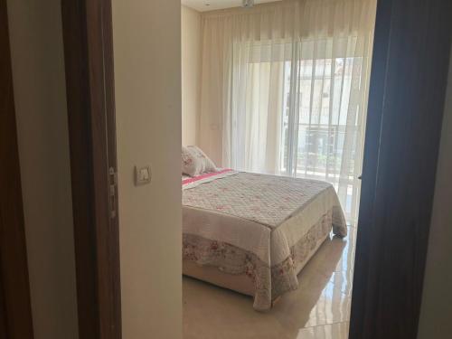 a bedroom with a bed in front of a window at Escapade à Sidi Rahal in Sidi Rahal