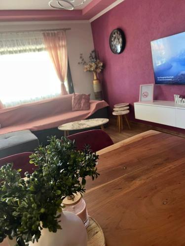 a living room with purple walls and a table with plants at MARIALENA HOMe in Petropiyí