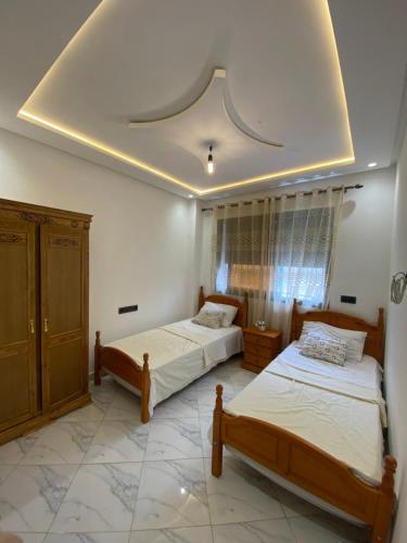 a bedroom with two beds and a ceiling at Appartement 2 chambres Martil in Martil