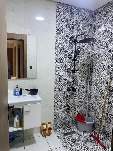 a bathroom with a shower with black and white tiles at Appartement 2 chambres Martil in Martil