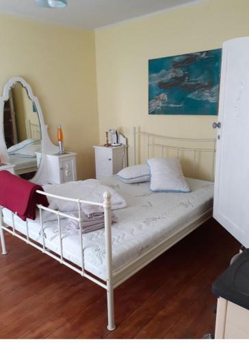 a white bed in a room with a mirror at Casa Luna Betiluna in Ciclova-Montană