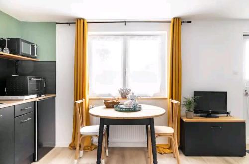 a small kitchen with a table and a window at le Studio Balnéo des Cocons de Mel in Quinssaines