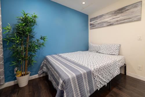 a bedroom with a bed and a blue wall at SF City Inn free parking on site in Oakland