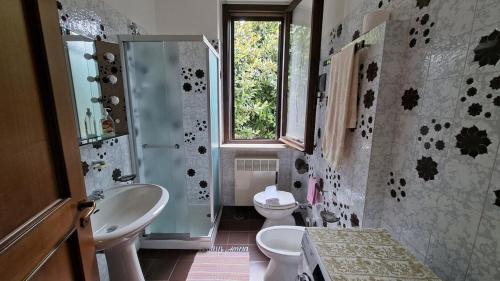 a bathroom with a sink and a toilet and a window at Lesa Lake House in Lesa