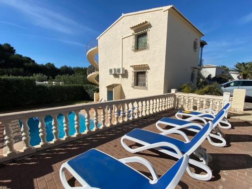 a row of blue and white lounge chairs on a balcony at Casa Luis - Javea - Spanien in Jávea