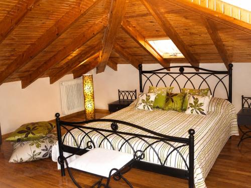 a bedroom with a black bed in a room with wooden ceilings at Filyra Pension in Nafplio