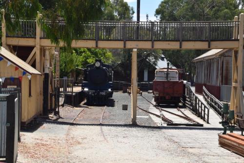 a train on the tracks under a bridge at Big River Motel in Echuca