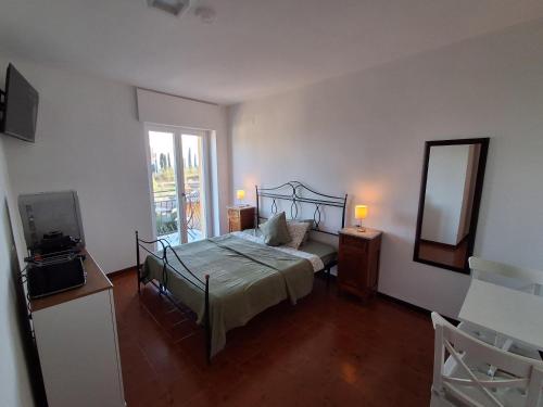 a bedroom with a bed and a mirror and a window at Alpina Sanico in Toscolano Maderno