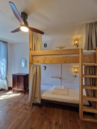 a bedroom with a bunk bed and a ceiling fan at COTTAGE - Utopy Hostel in Capbreton