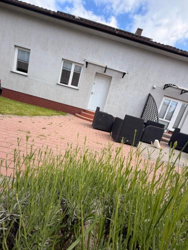 a house with black chairs in front of it at Słoneczne Ranczo Rowy in Rowy