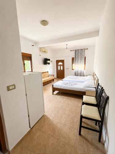a bedroom with a bed and a chair and a refrigerator at Tale Breeze Apartments in Tale