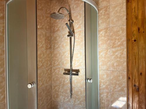 a shower with a shower head in a bathroom at Ūbelītes in Pērkone