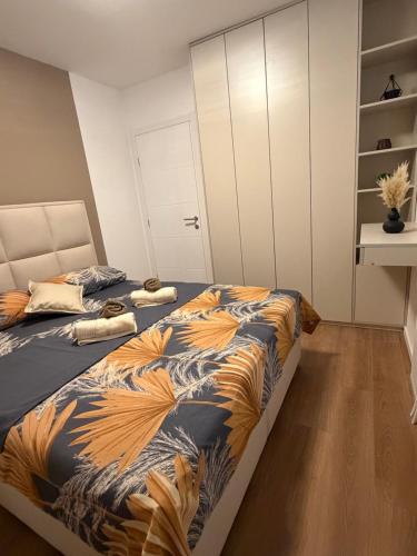 a bedroom with two beds and a white cabinet at Apartman Daniela Lake View in Donje Mladice