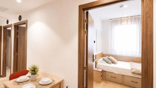 a bedroom with a bed and a table and a mirror at StepHouse Pamplona in Pamplona