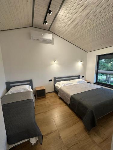 a bedroom with two beds and a window at Феєрія Лісу in Skhidnitsa