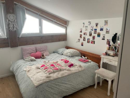 a bedroom with a bed with pink slippers on it at Maison de vacances à Bordeaux in Le Haillan