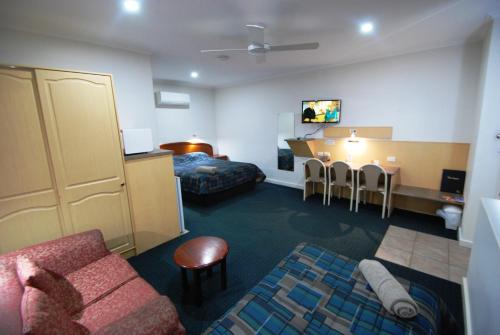 a hotel room with a couch and a dining room at Comfort Inn & Suites Augusta Westside in Port Augusta