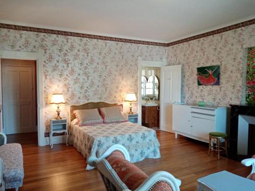 a bedroom with a bed with floral wallpaper at Villa Hestia B&B de charme dans une villa historique face aux thermes in Contrexéville