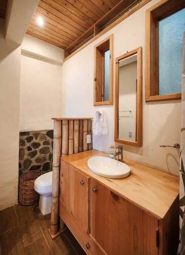 a bathroom with a sink and a toilet at Bambu Guest House in Tzununá