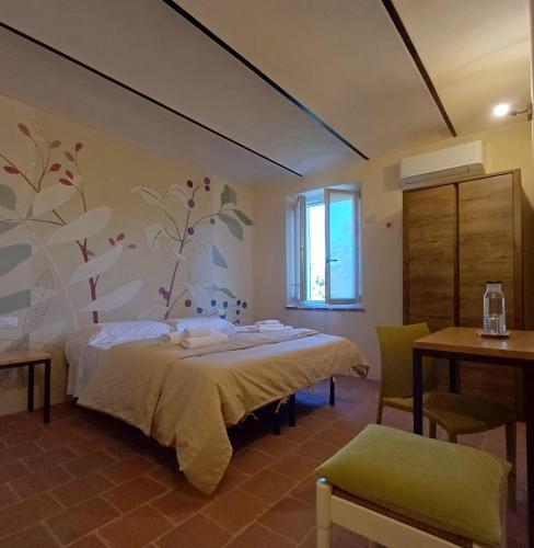 a bedroom with a bed and a table and a window at B&B La RU in Montemagno