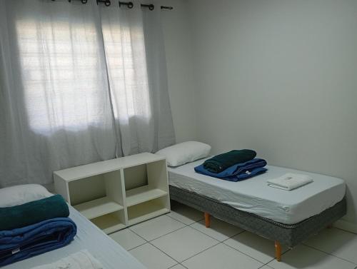 two twin beds in a room with a window at Recanto da Colônia in Ponta Grossa
