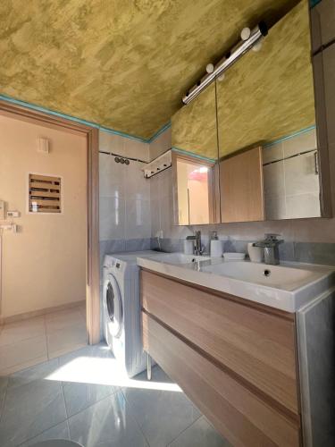 ein Badezimmer mit Waschbecken und Waschmaschine in der Unterkunft Rafina suits in Rafina