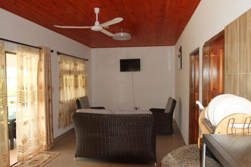 a living room with a ceiling fan and chairs at Tourterelle Holiday Home in Grand Anse