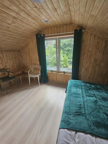 a bedroom with a bed and a table and a window at Sosnowa Ostoja Jurata in Jurata