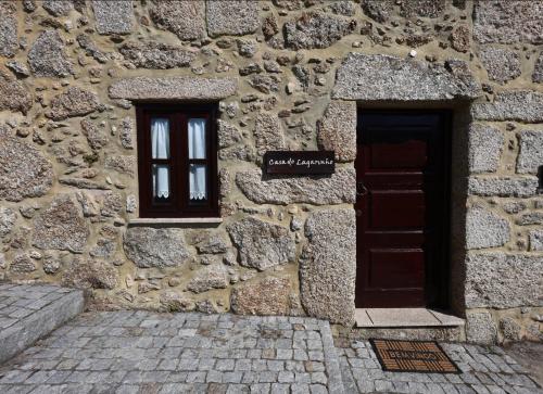 a stone building with two windows and a door at Casas Serranas in Gouveia
