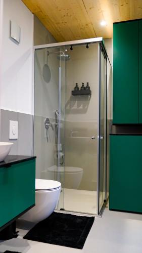 a bathroom with a glass shower with a toilet at Chalet du calme Augsburg in Augsburg