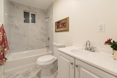 a white bathroom with a toilet and a sink at SF City Inn free parking on site in Oakland