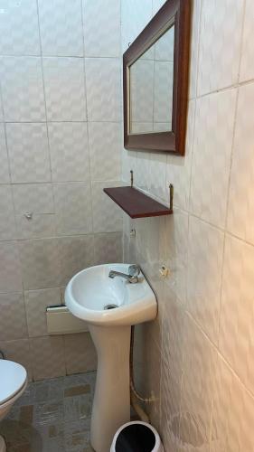 a bathroom with a sink and a mirror and a toilet at SWISS Residence Denver in Douala