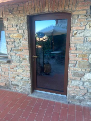 a glass door of a stone building with a patio at Residenze del Borgo in Zavattarello
