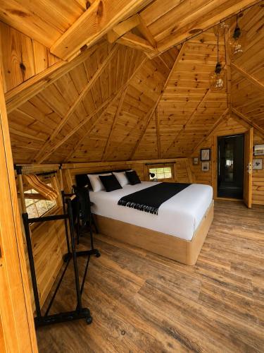 a bed in a room with a wooden ceiling at Kota Évasion & Spa in Cahors