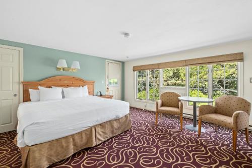 a hotel room with a bed and a table and chairs at The Corsair & Cross Rip Oceanfront in Dennis Port
