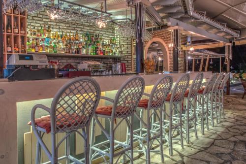 a row of chairs sitting in front of a bar at Iliada Beach Hotel in Gouvia