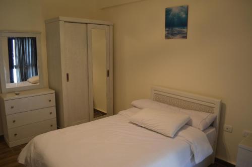 a bedroom with a bed and a dresser and a mirror at Pool View Chalet in El Alamein